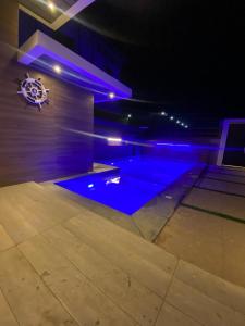 塞拉莱Platinum plus mirbat的蓝色灯光的房间的游泳池