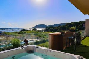 维琪奥港CALADEA Locations de Vacances 5 étoiles, piscine chauffée的阳台上的热水浴池享有水景