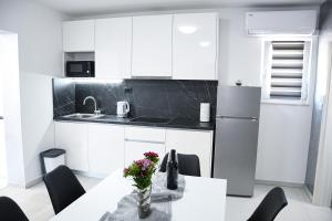 斯塔布鲁克Apartment Light的厨房配有白色橱柜和鲜花桌