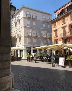 维罗纳欧罗巴酒店的前面有桌子和伞的建筑