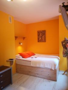 德武戈波莱兹德鲁伊Pod Gadającym Kotem的一间卧室拥有橙色的墙壁,里面设有一张床