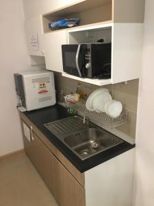 曼谷Supalai Rama9 Monthly的厨房配有水槽和微波炉