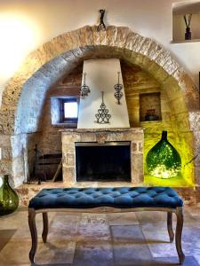 阿尔贝罗贝洛特鲁利普利亚度假旅馆的客厅设有石制壁炉和蓝色长凳