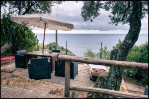 弗拉穆拉Corner of Paradise near Cinque Terre的围栏旁带雨伞的桌子