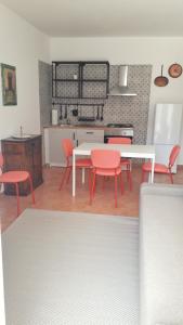圣雷莫MAX and SUN parking privato nel prezzo的厨房配有红色的椅子和白色的桌子