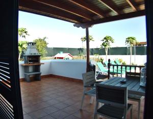普拉亚布兰卡Villa Raima的一个带烧烤架和桌椅的庭院