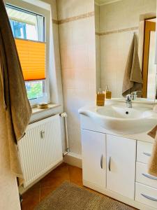 塔勒Ferienwohnung Alte Quickbox的一间带白色水槽和窗户的浴室