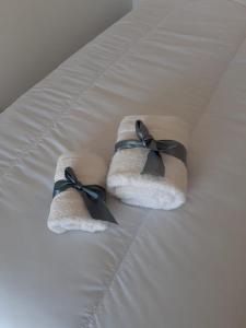 布宜诺斯艾利斯Parque Patricios 2 ambientes的床上的两条带黑色弓的毛巾