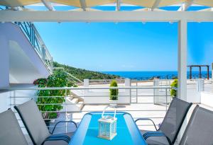 斯卡拉马里昂Tarsa's House by the Sea的阳台配有蓝色的桌椅和海洋