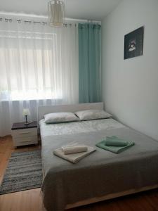 什切青Pomaranczowa Apartment的一间卧室配有一张床,上面有两条毛巾
