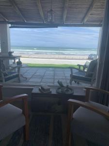 梅尔克博斯特兰Dreamy Beach Room的配有椅子并享有海滩景致的客房