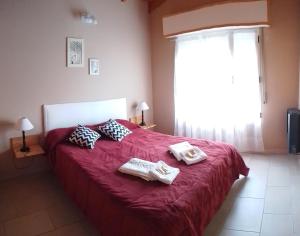 本塔纳山村Cabañas Los Troncos的一间卧室配有红色的床和2条毛巾
