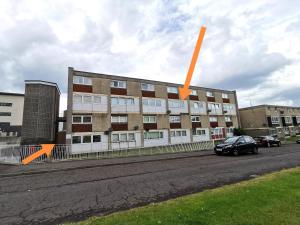 格拉斯哥Glasgow Apartment Cozy and ultramodern的一座建筑的侧面有橙色箭头