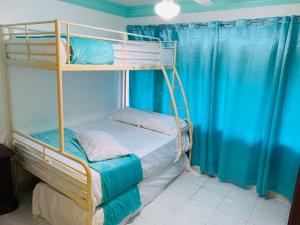 璜多里奥La Gaviota B1的一间卧室配有两张双层床和蓝色窗帘