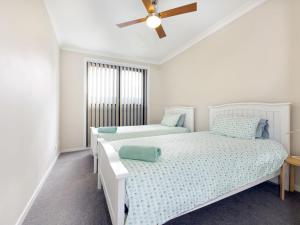 凯阿玛Surf Beach Dreams的一间卧室配有两张床和吊扇