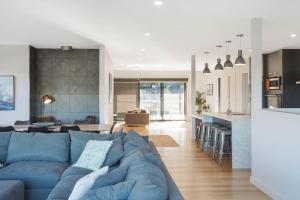 伊登Kingfisher Retreat @ Eden Cove的客厅和带蓝色沙发的厨房