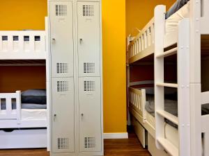 考纳斯RailWay Bed HOSTEL的双层床间 - 带白色双层床和黄色墙壁
