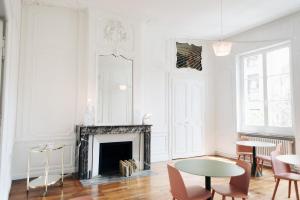 梅斯Hotel de Fouquet - Chambres d'hôtes的客厅设有白色的墙壁和壁炉。