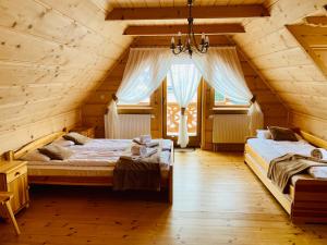 CzerwienneDom Pod Bachledówką的小木屋内一间卧室,配有两张床