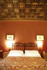 博洛尼亚德拉佩里旅馆的一间卧室配有一张带橙色墙壁的大床