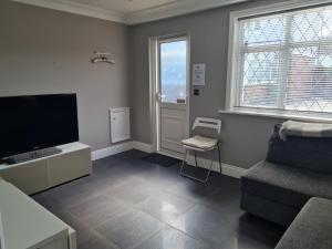 切辛顿Private luxury Annex apartment with secure free parking的客厅配有平面电视和椅子。