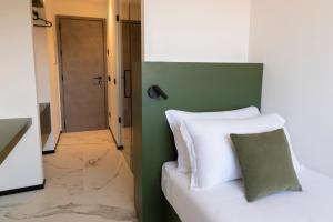 安科纳The City Hotel的卧室配有白色的床和绿色的墙壁