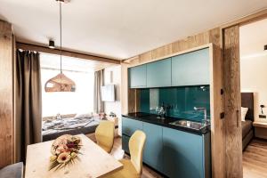 修希Mysciliar Apartment Tree I的一间厨房,内设蓝色橱柜和一张桌子