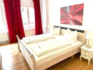 林道Hotel Garni Anker的红色窗帘的房间的一张床位