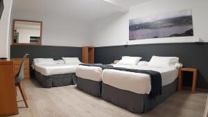 维戈维哥海滨酒店的带镜子的客房内设有两张床的房间