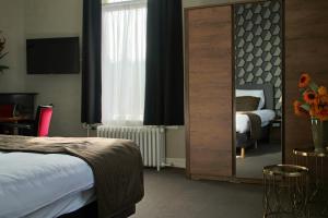 Terborg泰尔博赫德鲁德莱乌酒店的酒店客房,配有床和镜子