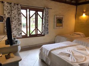 朱奎Pousada Baobá的一间卧室设有两张床和窗户。
