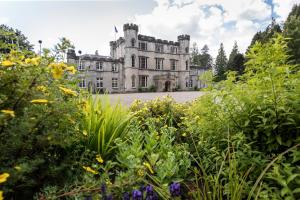 爱丁堡Melville Castle Hotel的一座古老的城堡,前面有一个花园