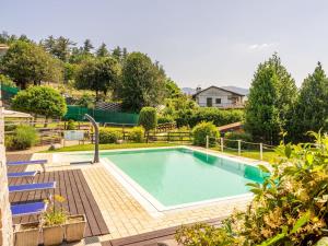勒威诺Holiday Home Residenza Agrifoglio-12 by Interhome的游泳池周围设有两把蓝色椅子