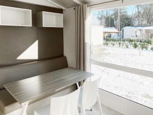 斯欣费尔德Holiday Home De Brenkberg-1的一间带桌椅和窗户的用餐室