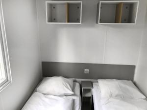 斯欣费尔德Holiday Home De Brenkberg-1的小房间设有两张床和两面镜子