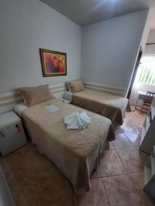 迪亚曼蒂纳Pousada Guinda DIAMANTINA -MG的一间客房配有两张床和一张沙发