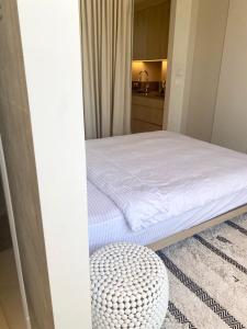 荷兹利亚daniel hotel beach view boutique apt的一间带一张床和一张搁脚凳的小卧室