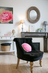 佩里格Logis des Halles du Coderc的客厅配有带粉红色枕头的黑椅