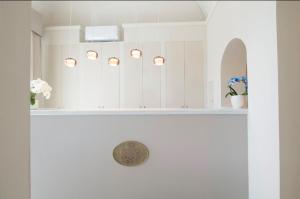 维亚雷焦伦敦酒店的浴室设有白色橱柜和鲜花水槽。