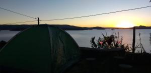 奥科苏尤Amantani Lodge的绿色帐篷,背面是日落