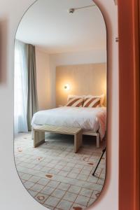 热夫雷尚贝尔坦Hôtel Ô Rouge Gevrey-Chambertin - Teritoria的一间卧室配有一张床和镜子