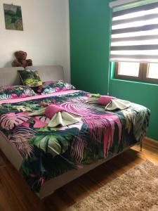 新瓦罗什Apartmani NINA Zlatar的卧室内一张带五颜六色棉被的床