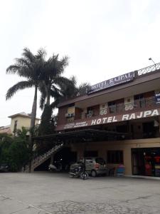 德拉敦Hotel Rajpal Guest House的一座酒店大楼,前面有棕榈树