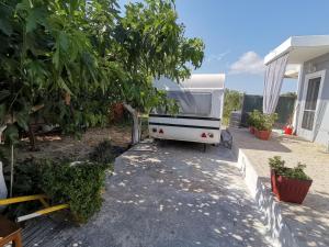 扎金索斯镇Green Garden Caravan的停在房子外的白色露营车