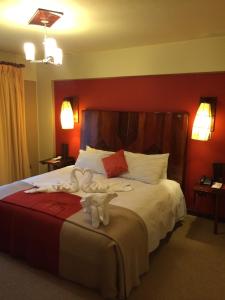 普诺普诺皇家酒店的一间卧室配有一张床,上面有两条毛巾
