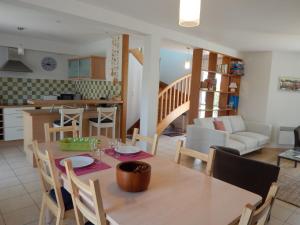 吉尔维内克Brise Océane的厨房以及带木桌和椅子的客厅。