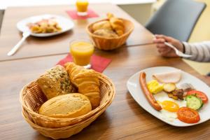 巴登-巴登Hotel Quellenhof的一张桌子,上面放着一篮早餐食品和橙汁