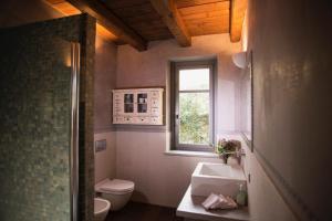 安杰拉Cascina Canée的一间带水槽和卫生间的浴室以及窗户。