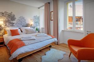 安锡Le SwansDoors - OVO Network的一间卧室配有一张带橙色椅子的床和一扇窗户