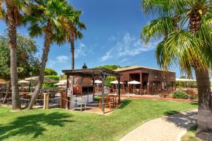 阿尔布费拉AP Adriana Beach Resort的棕榈树度假村和餐厅